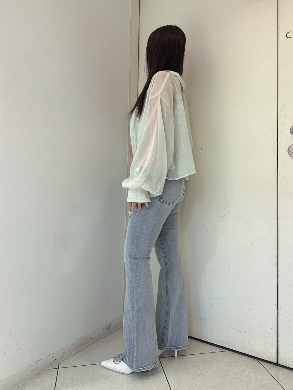 ブルー系のデニムパンツ、グリーン系のシャツ/ブラウス、ホワイト系のチューブトップを着用したレディースの春コーディネートの2枚目の写真