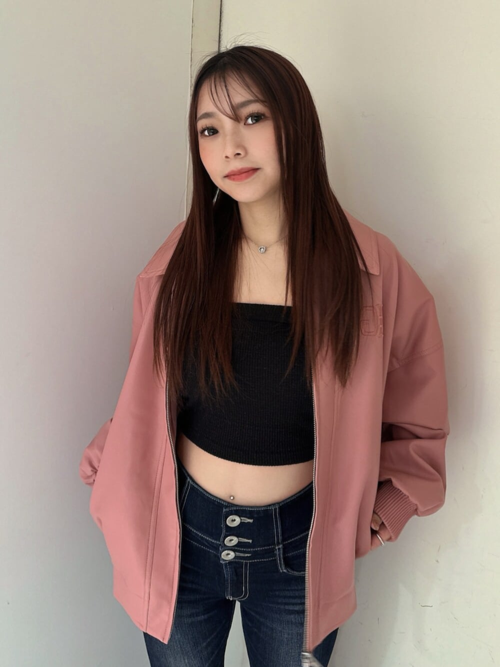 ブルー系のデニムパンツ、ブラック系のサンダル、ピンク系のブルゾンを着用したレディースの春コーディネートの4枚目の写真