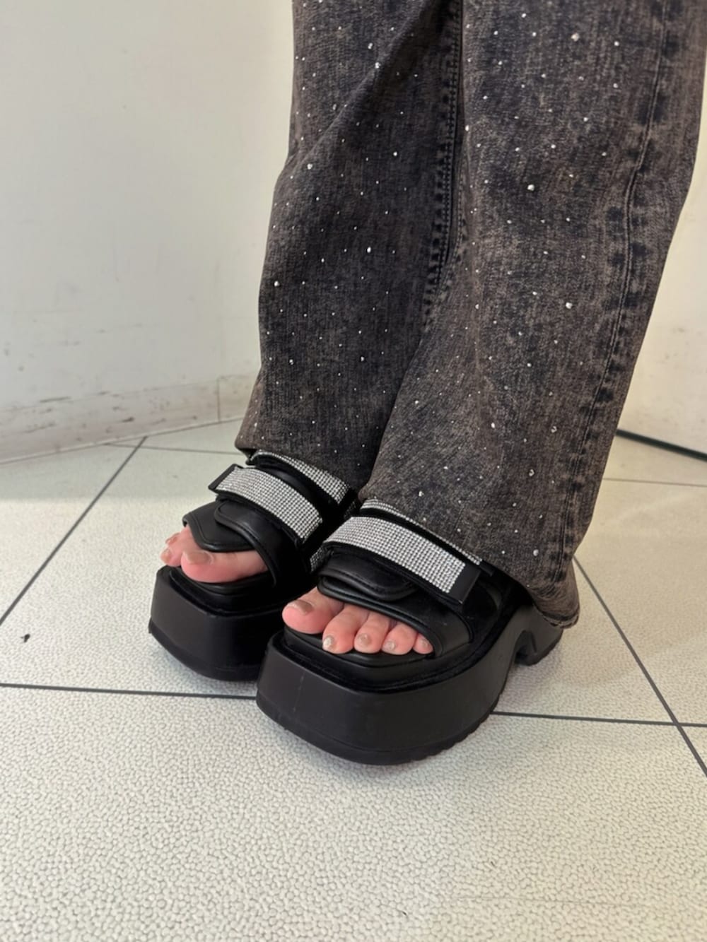 ブラック系のサンダル、ブルー系のデニムパンツ、ブラック系のTシャツ/カットソーを着用したレディースの夏コーディネートの9枚目の写真