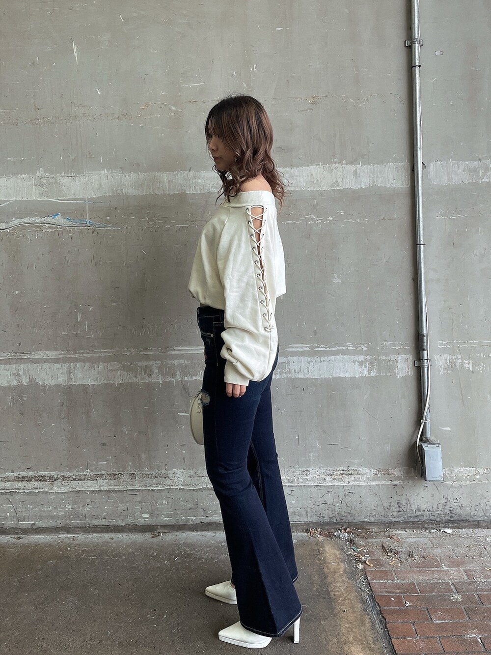 ホワイト系のスウェット、ホワイト系のハンドバッグ、ホワイト系のパンプスを着用したレディースの春コーディネートの3枚目の写真