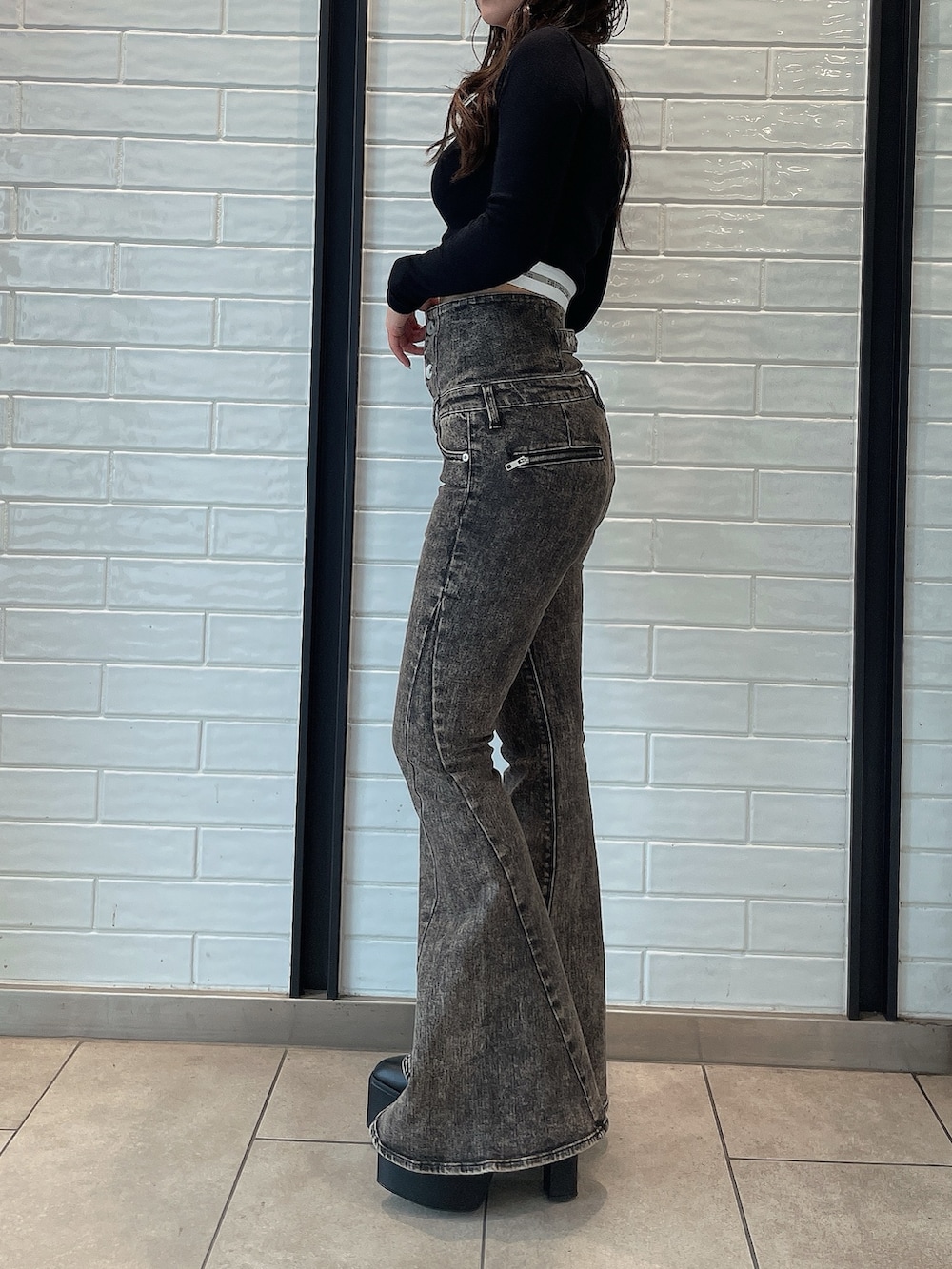 ブラック系のデニムパンツ、ブラック系のブーツ、ブラック系のTシャツ/カットソーを着用したレディースの夏コーディネートの2枚目の写真