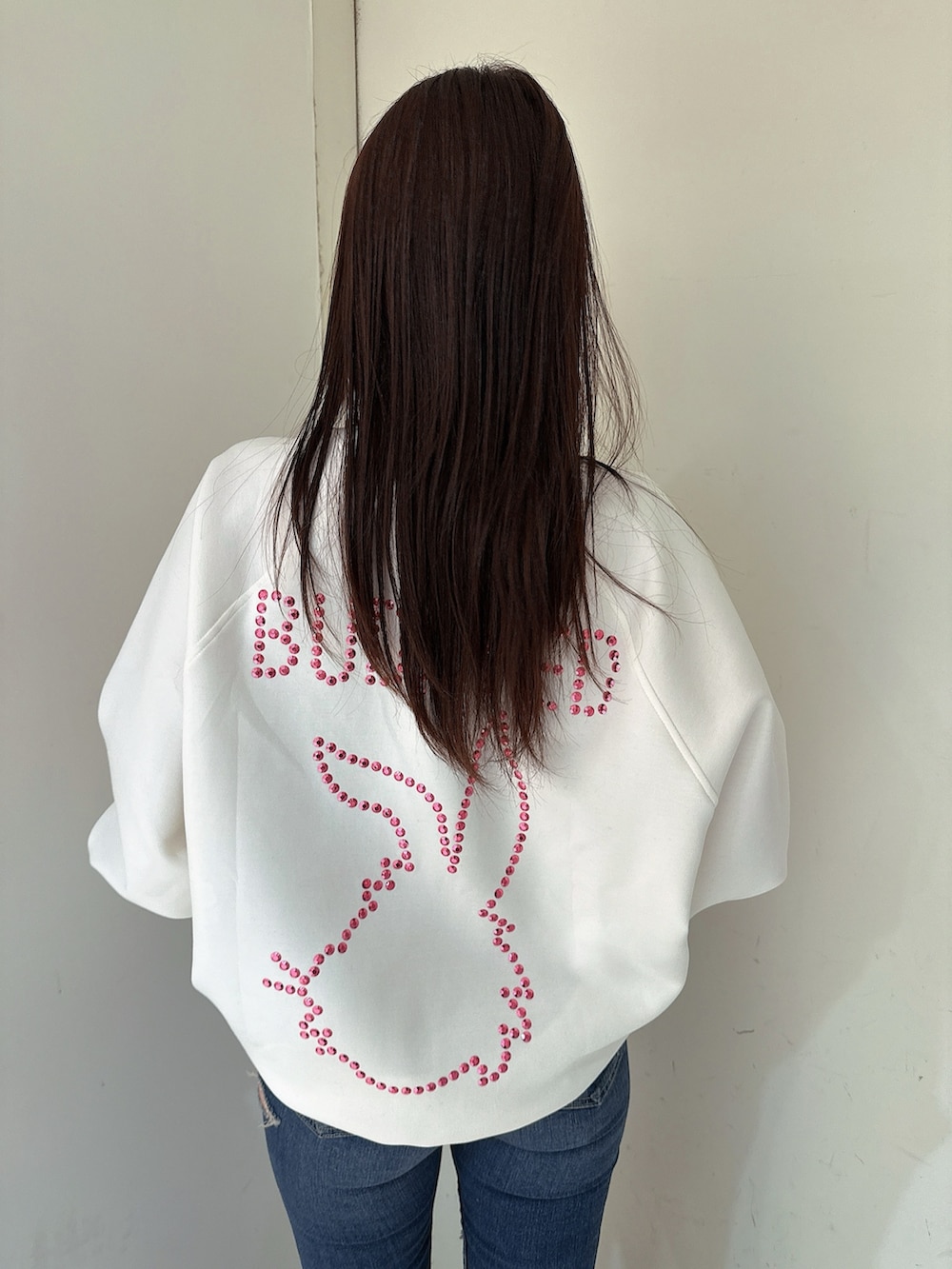 ブルー系のデニムパンツ、ブラック系のブーツ、ホワイト系のスウェットを着用したレディースの冬コーディネートの6枚目の写真