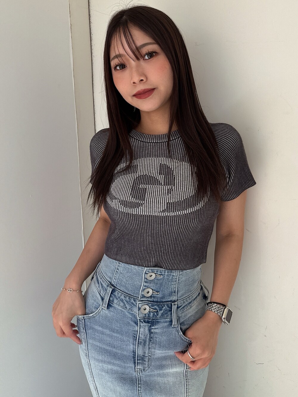 ホワイト系のニット/セーター、ブルー系のデニムスカート、ホワイト系のサンダルを着用したレディースの夏コーディネートの4枚目の写真