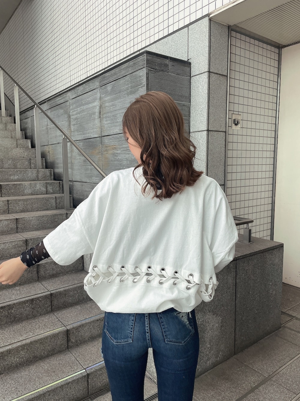 ブルー系のデニムパンツ、ブラック系のパンプス、ブラック系のTシャツ/カットソーを着用したレディースの春コーディネートの4枚目の写真