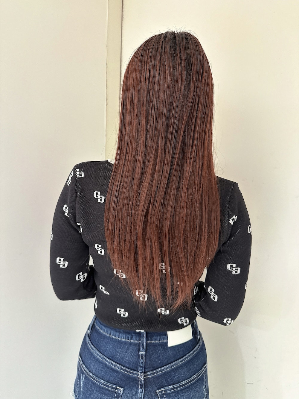 ブラック系のブーツ、ブルー系のデニムパンツ、ブラック系のニット/セーターを着用したレディースの冬コーディネートの6枚目の写真