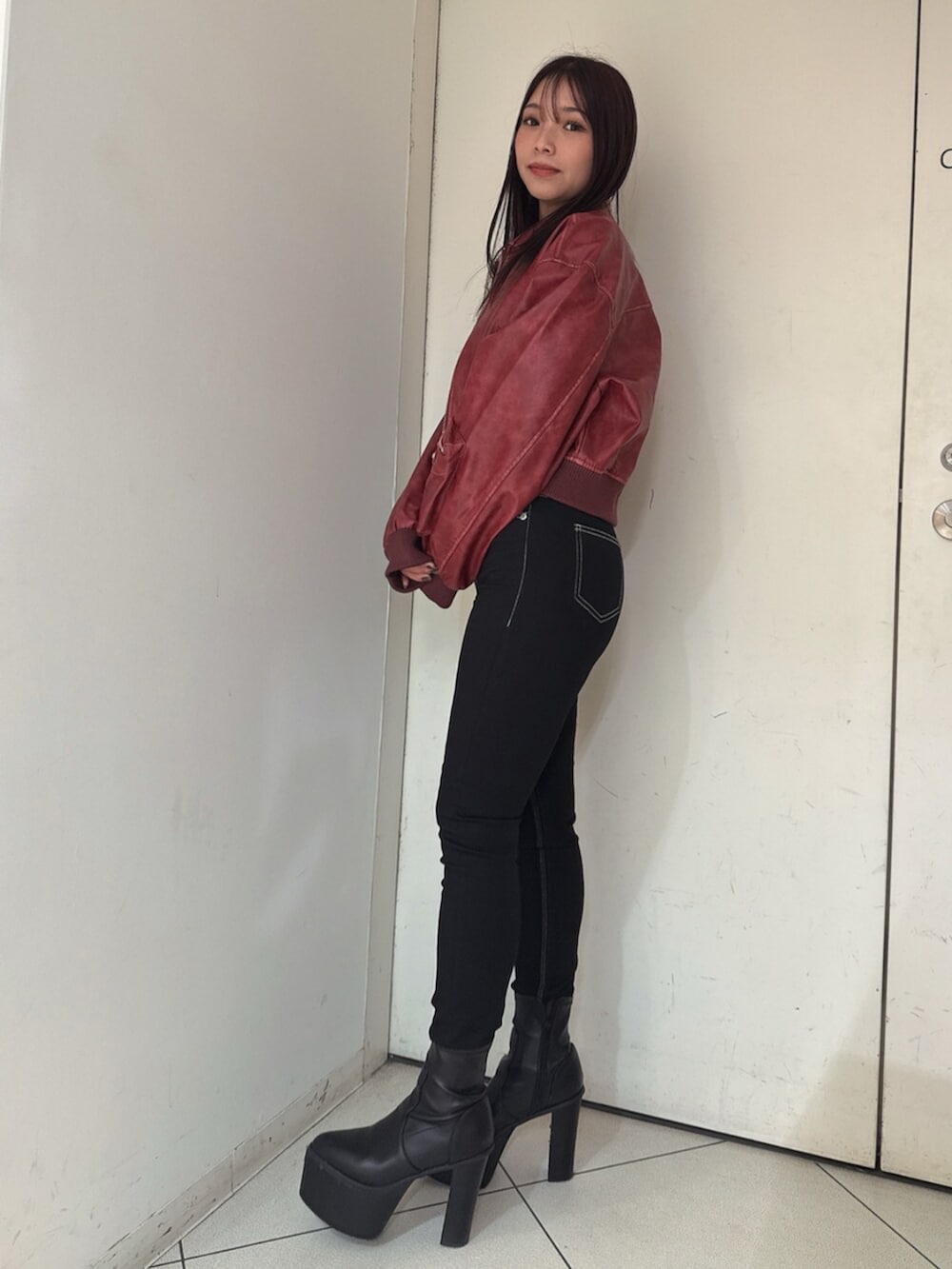 ブラック系のデニムパンツ、ブラック系のブーツ、ブラック系のニット/セーターを着用したレディースの秋コーディネートの2枚目の写真