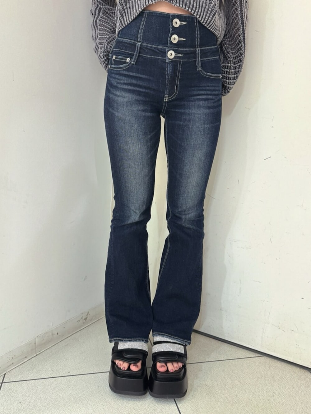 ブルー系のデニムパンツ、ブラック系のサンダル、ホワイト系のブルゾンを着用したレディースの春コーディネートの9枚目の写真