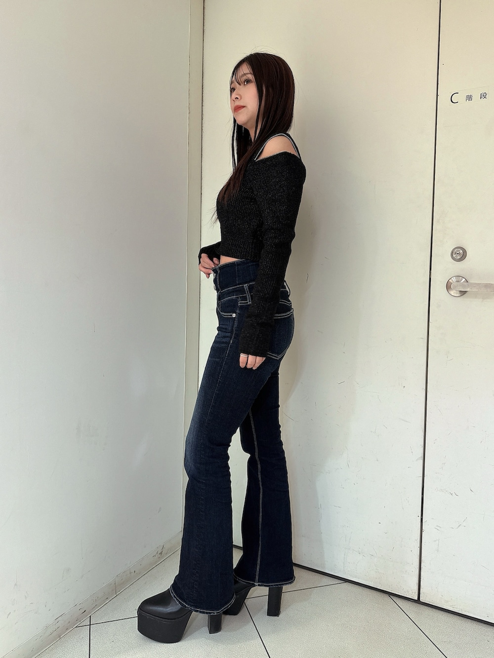 ブルー系のデニムパンツ、ブラック系のブーツ、ブラック系のニット/セーターを着用したレディースの冬コーディネートの2枚目の写真