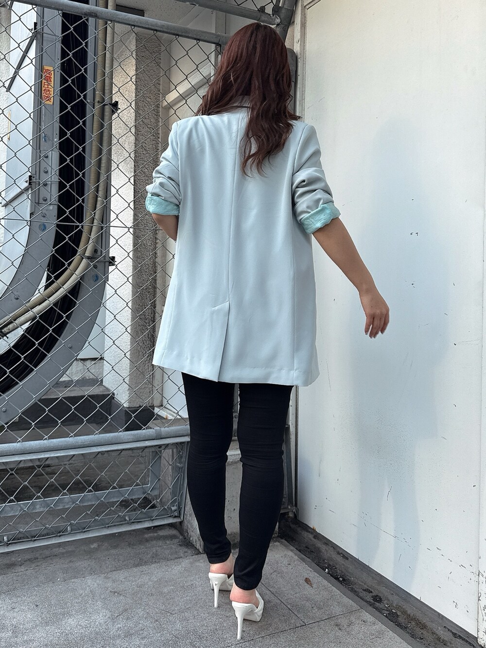 ブラック系のキャミソール、ブラック系のデニムパンツ、ホワイト系のパンプスを着用したレディースの春コーディネートの3枚目の写真