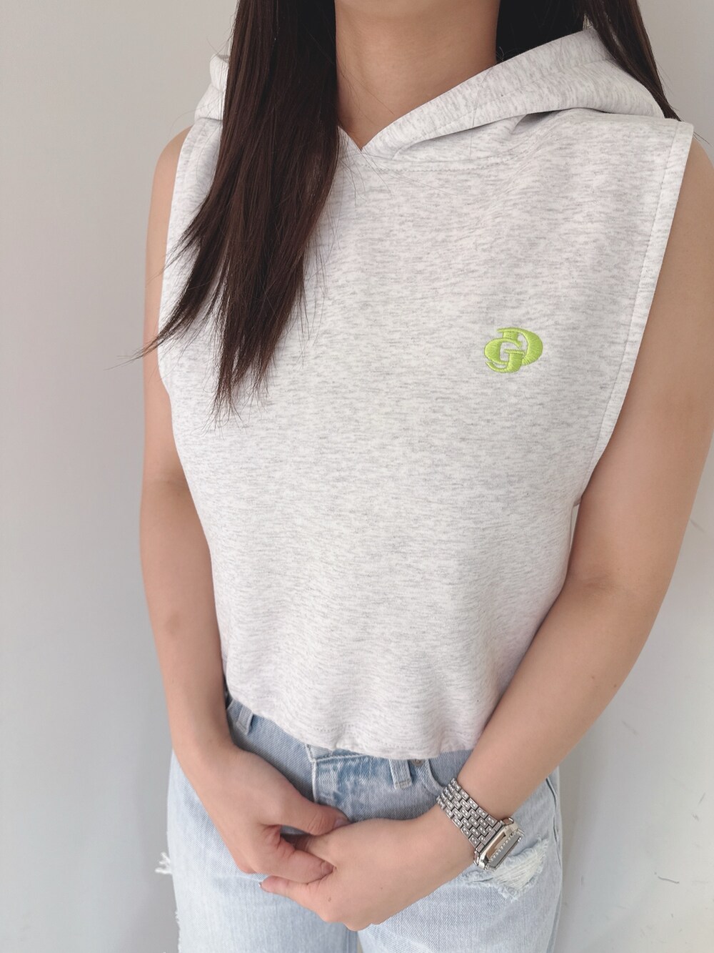 グレー系のパーカー、ブルー系のデニムパンツ、ホワイト系のサンダルを着用したレディースの夏コーディネートの7枚目の写真