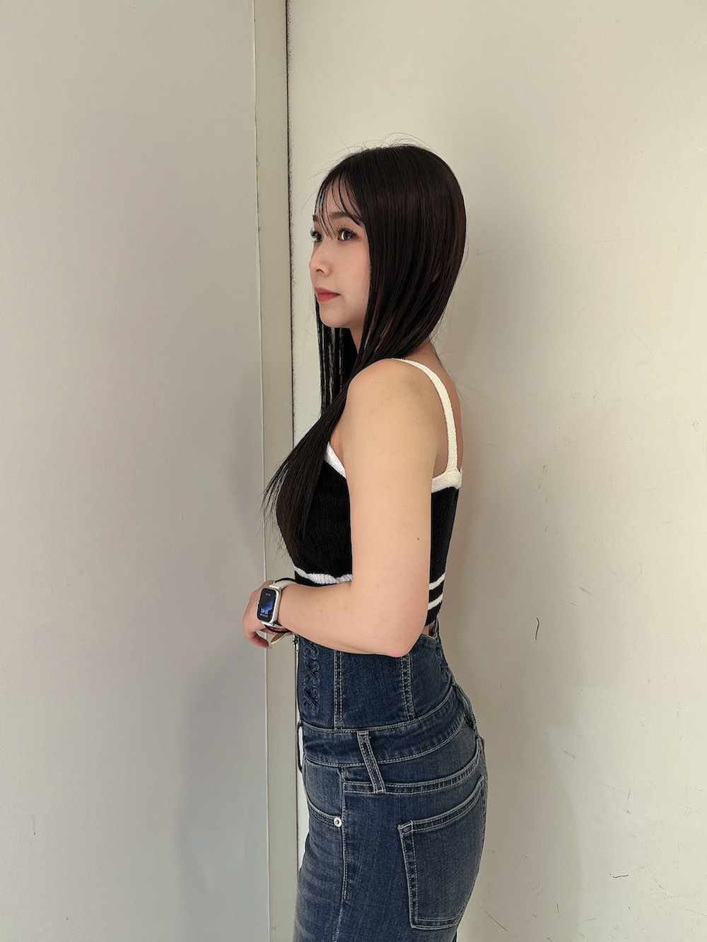 ブルー系のデニムパンツ、ブラック系のキャミソール、ブラック系のサンダルを着用したレディースの春コーディネートの5枚目の写真