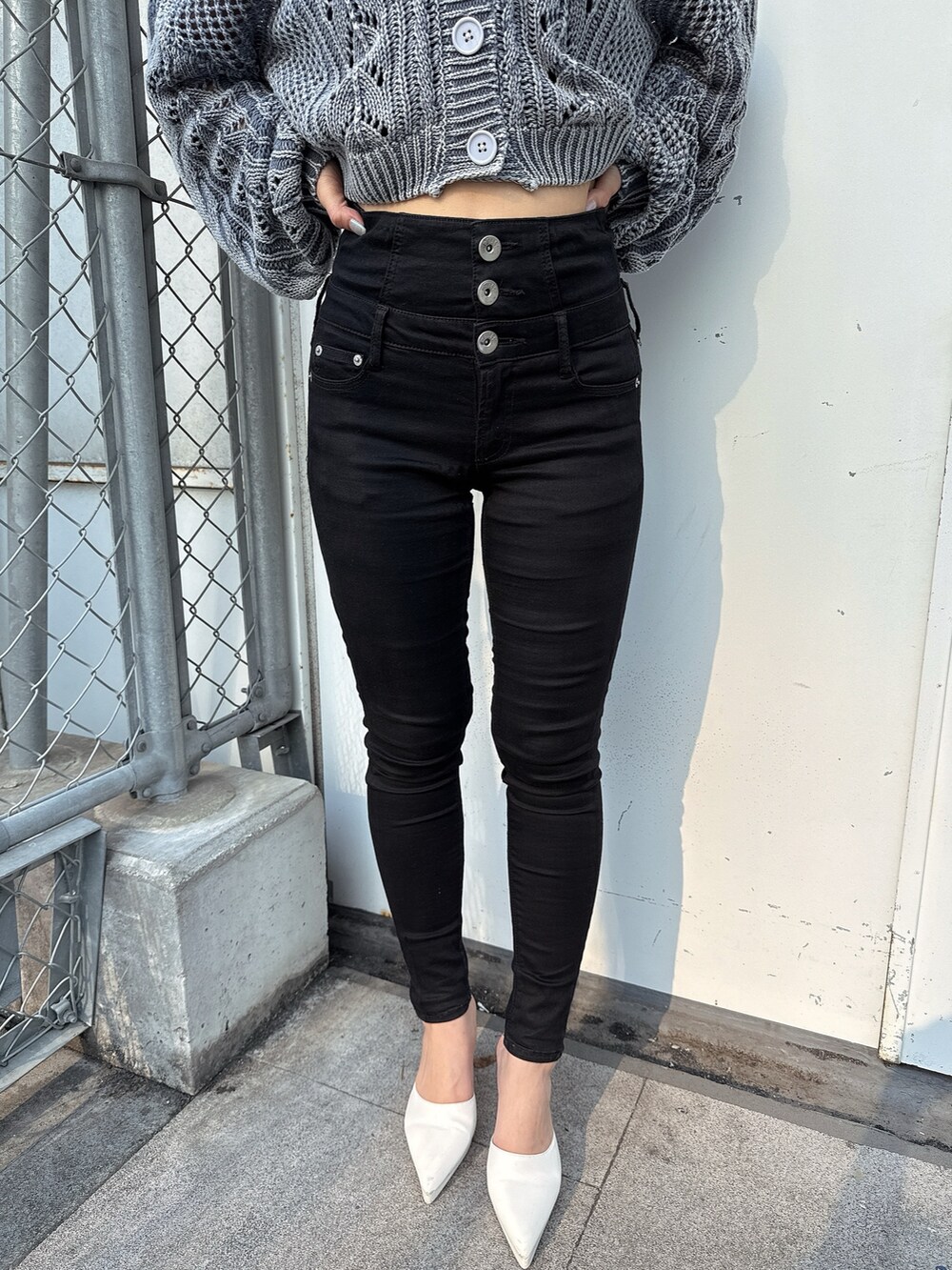 ブルー系のニット/セーター、ブラック系のデニムパンツ、ホワイト系のパンプスを着用したレディースの春コーディネートの8枚目の写真