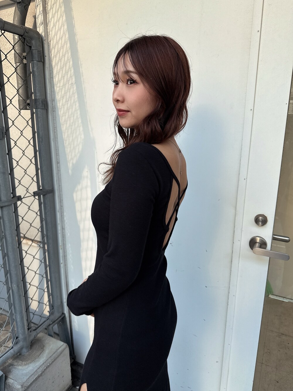 ブラック系のワンピース、ホワイト系のブーツを着用したレディースの春コーディネートの6枚目の写真