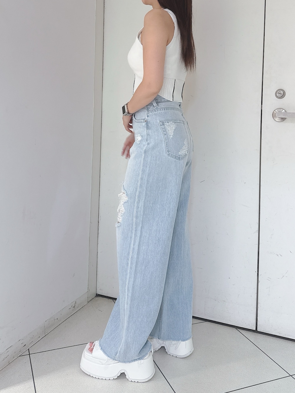 ホワイト系のニット/セーター、ブルー系のデニムパンツ、ホワイト系のサンダルを着用したレディースの夏コーディネートの2枚目の写真