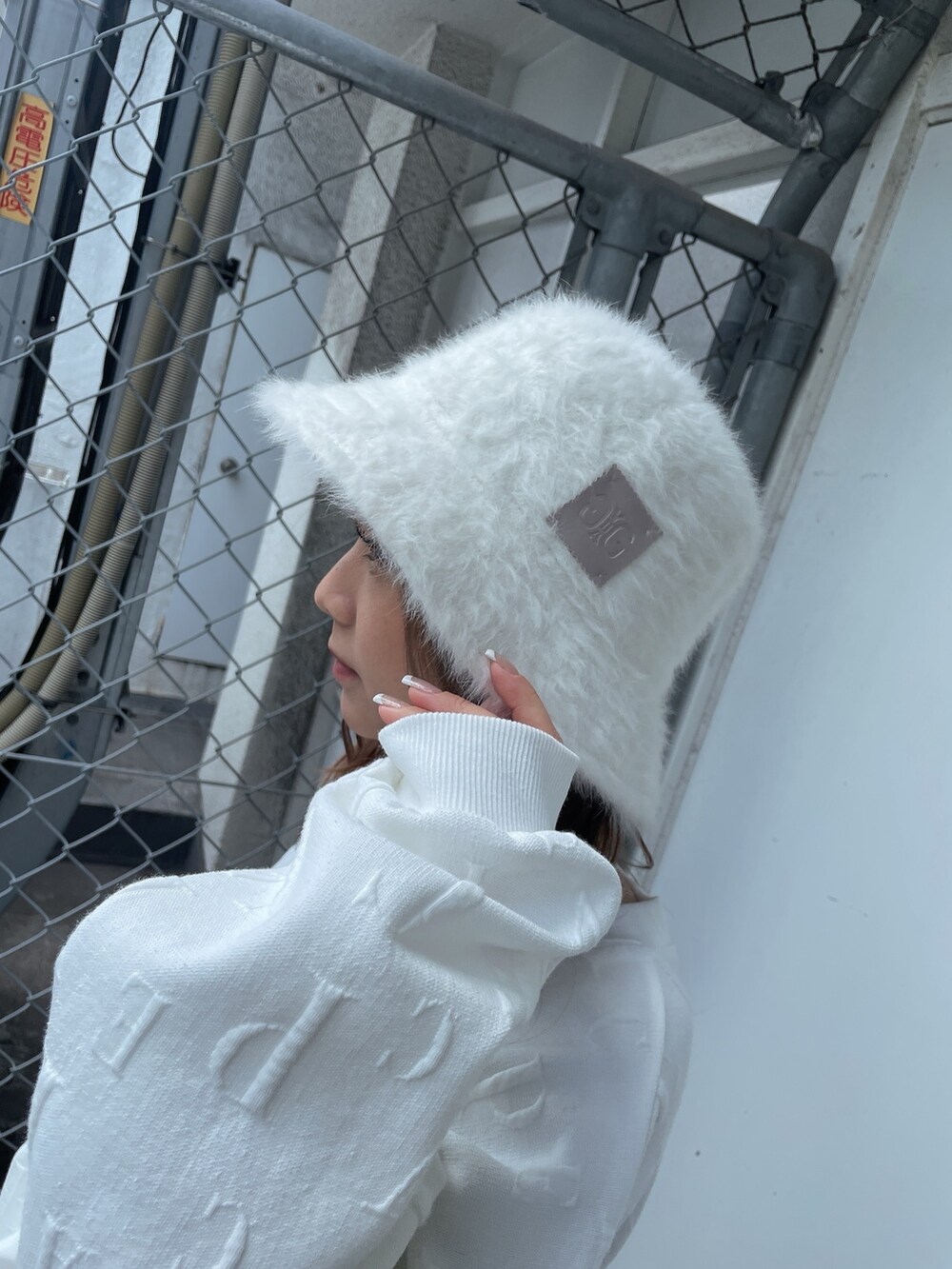 ホワイト系のスウェット、ブラック系のスカート、ベージュ系のブーツを着用したレディースの冬コーディネートの8枚目の写真