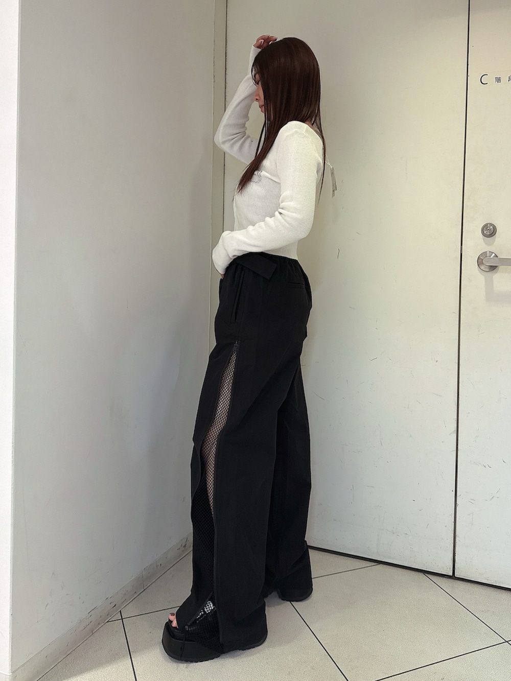 ブラック系のその他パンツ、ブラック系のサンダル、ホワイト系のニット/セーターを着用したレディースの春コーディネートの2枚目の写真