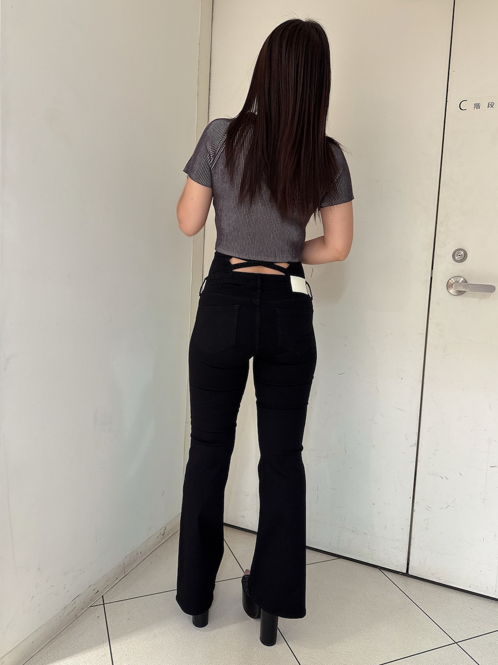 ホワイト系のニット/セーター、ブルー系のデニムパンツ、ブラック系のサンダルを着用したレディースの夏コーディネートの3枚目の写真