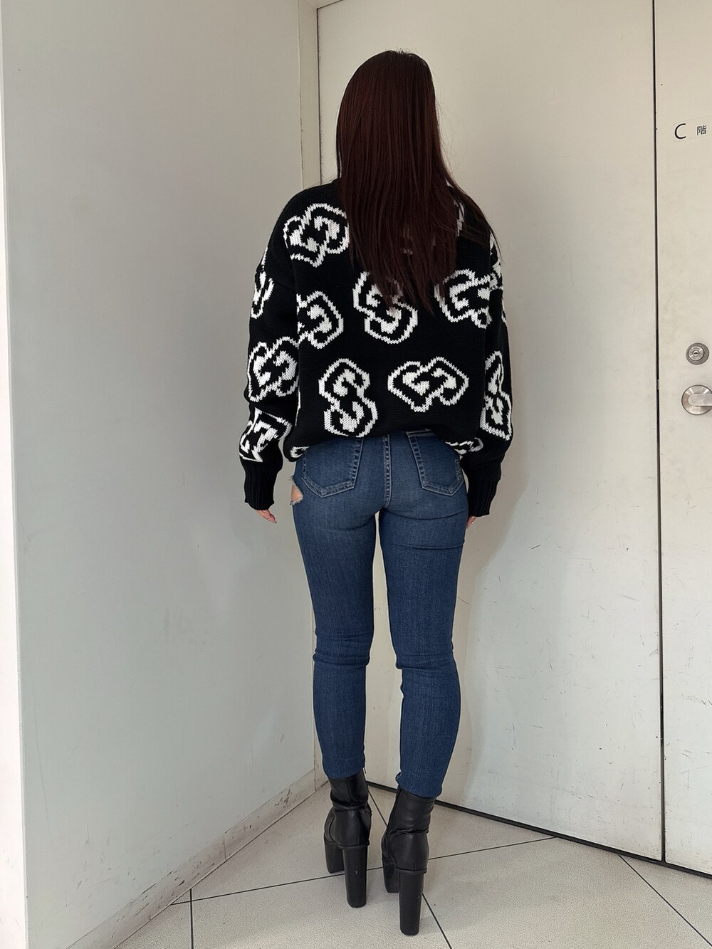 ブラック系のブーツ、ブルー系のデニムパンツ、ブラック系のニット/セーターを着用したレディースの秋コーディネートの3枚目の写真