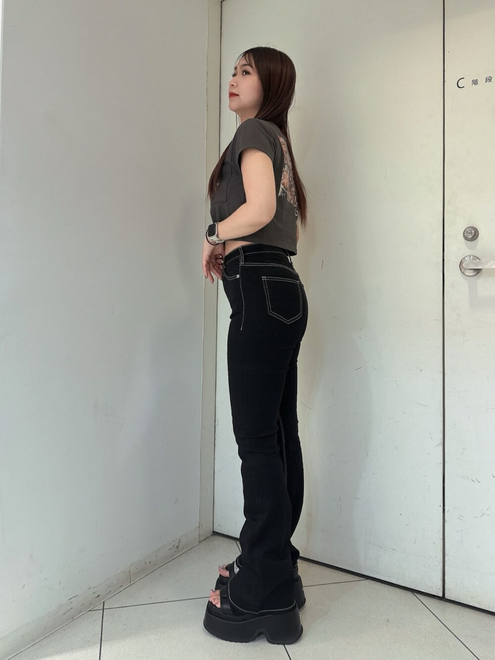 ブラック系のサンダル、ブラック系のデニムパンツ、グレー系のTシャツ/カットソーを着用したレディースの春コーディネートの2枚目の写真