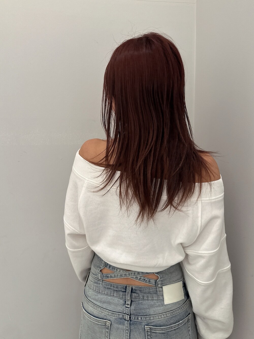 ブルー系のデニムパンツ、ホワイト系のパンプス、ホワイト系のスウェットを着用したレディースの冬コーディネートの6枚目の写真