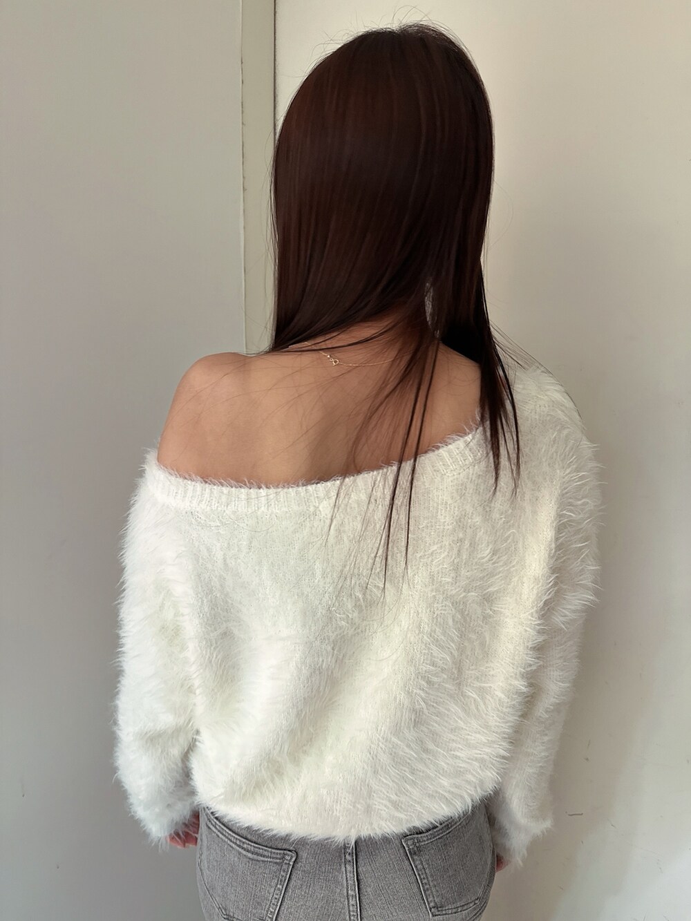 ホワイト系のニット/セーター、グレー系のデニムパンツ、ブラック系のブーツを着用したレディースの冬コーディネートの6枚目の写真