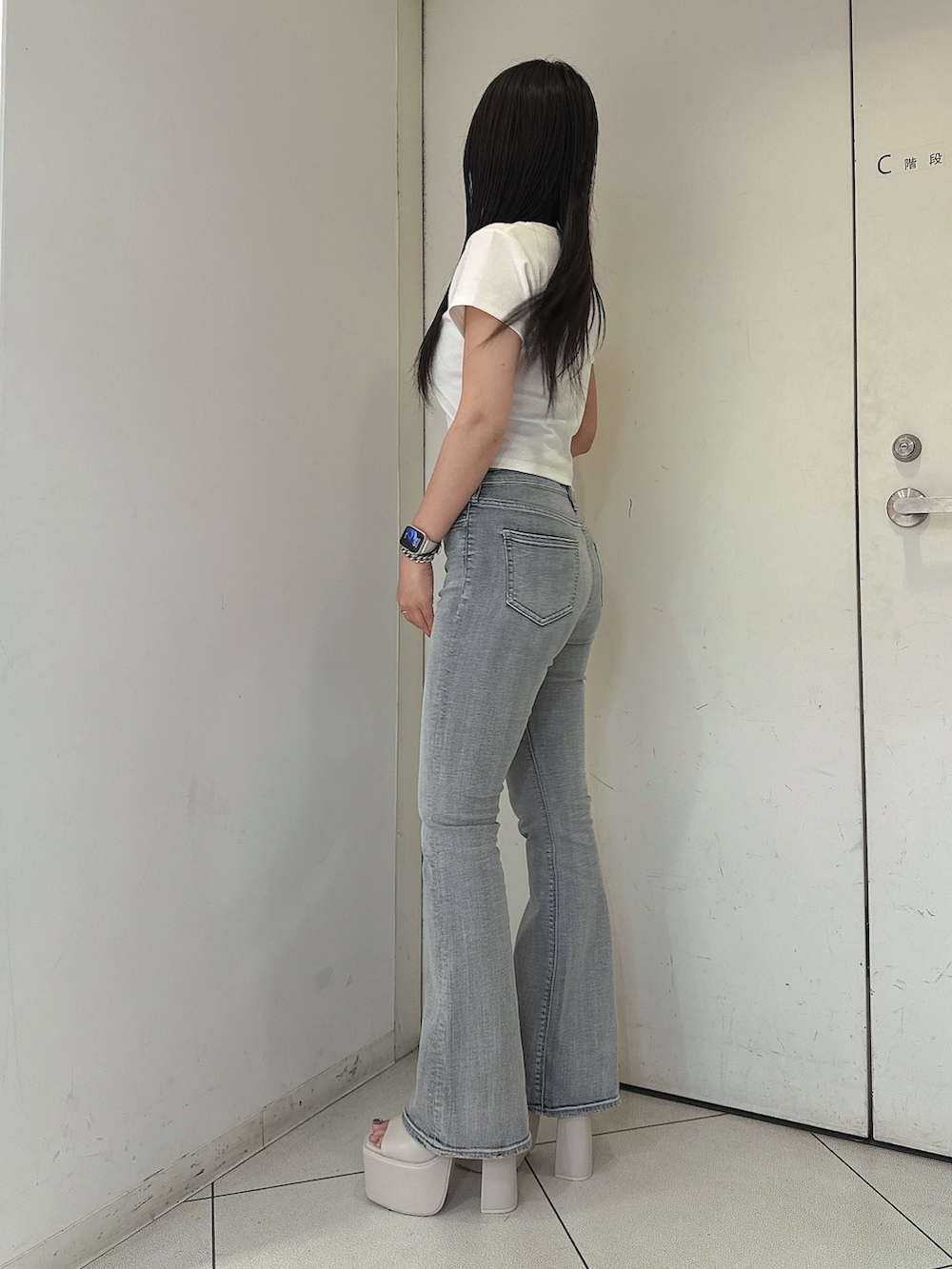ブルー系のデニムパンツ、ホワイト系のTシャツ/カットソー、ホワイト系のサンダルを着用したレディースの春コーディネートの2枚目の写真