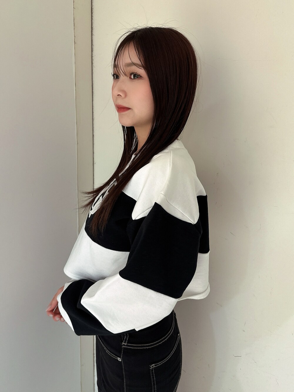 ブラック系のデニムパンツ、ブラック系のブーツ、ホワイト系のTシャツ/カットソーを着用したレディースの冬コーディネートの5枚目の写真