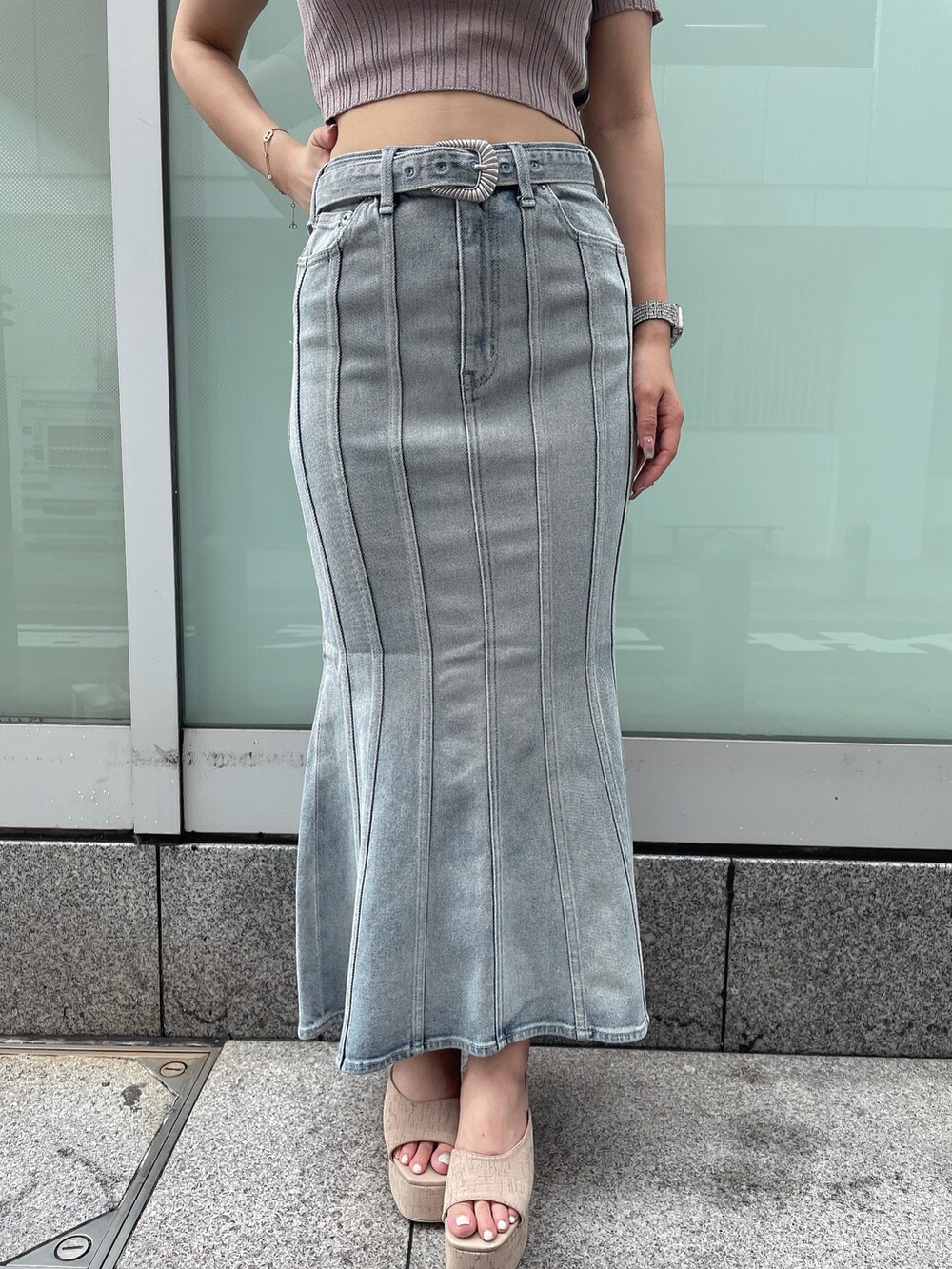 ブルー系のデニムスカート、ホワイト系のサンダル、ホワイト系のニット/セーターを着用したレディースの夏コーディネートの7枚目の写真