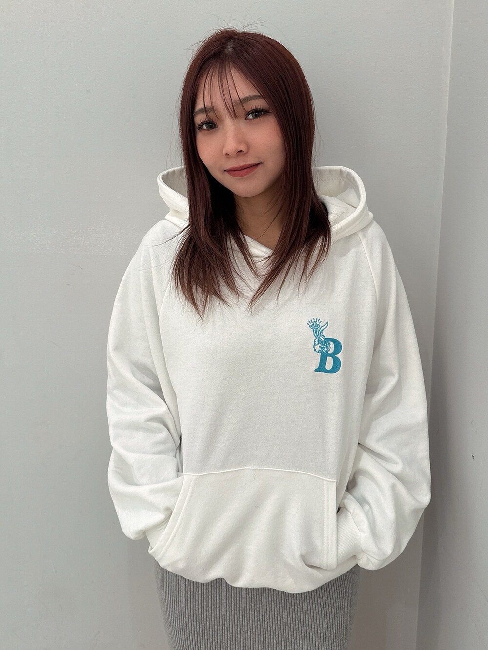 グレー系のワンピース、ホワイト系のパーカー、ブラック系のブーツを着用したレディースの冬コーディネートの4枚目の写真