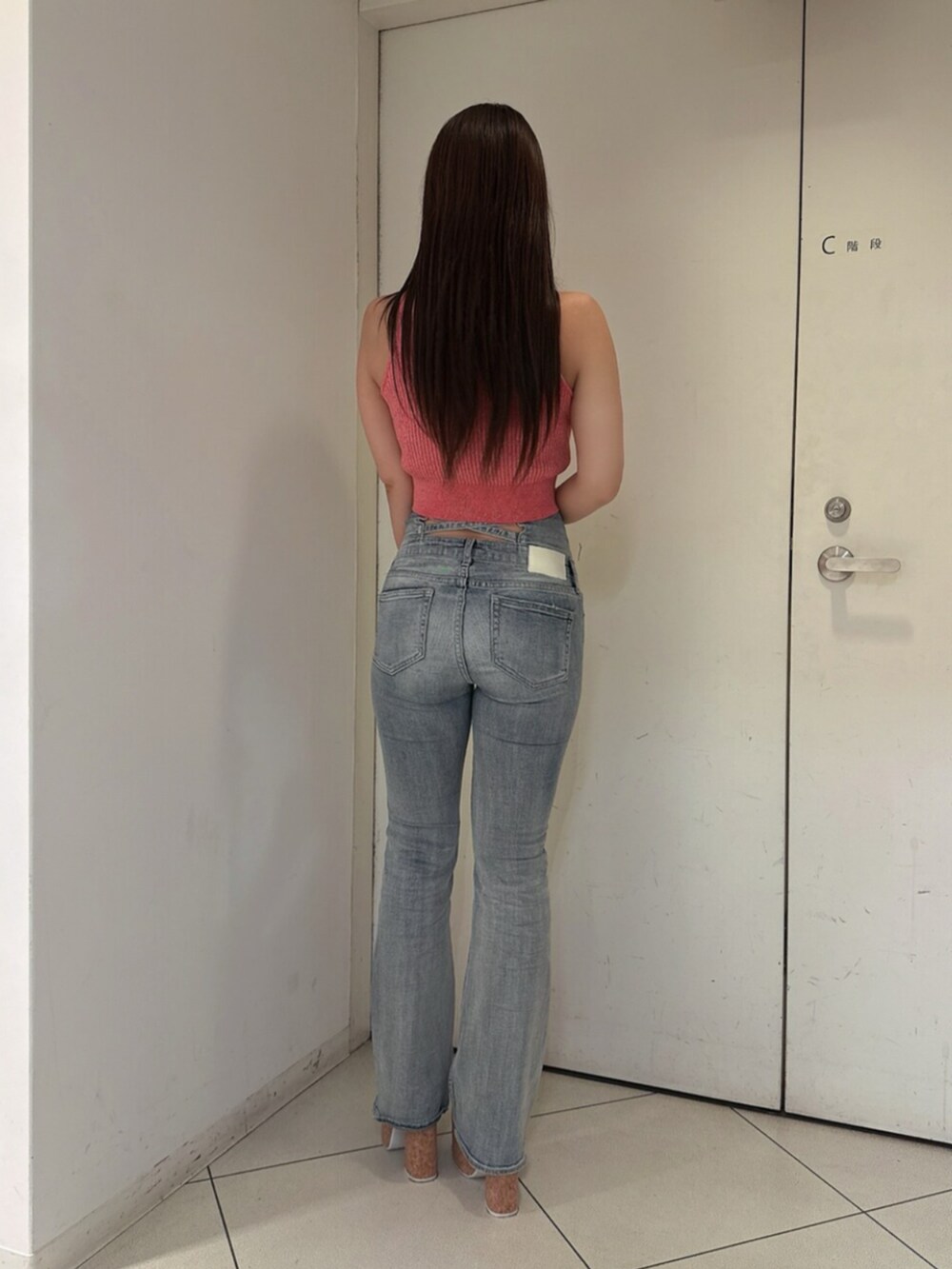 ブルー系のデニムパンツ、ホワイト系のサンダル、ピンク系のタンクトップを着用したレディースの夏コーディネートの3枚目の写真