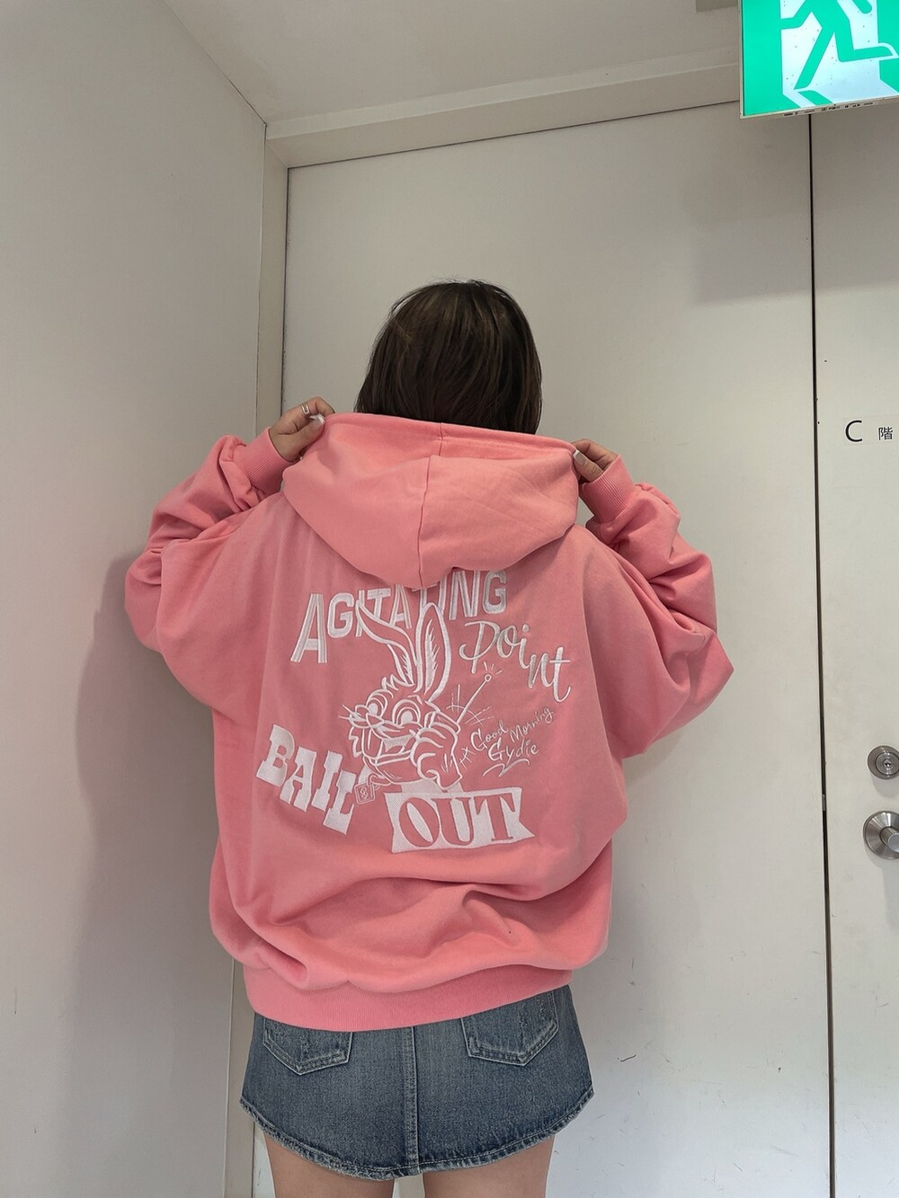 ピンク系のパーカー、ブルー系のデニムスカートを着用したレディースの冬コーディネートの4枚目の写真