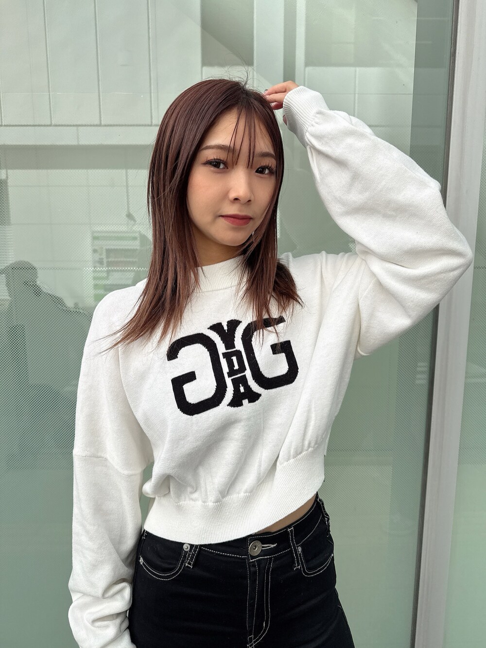 ブラック系のデニムパンツ、ブラック系のブーツ、ホワイト系のニット/セーターを着用したレディースの秋コーディネートの8枚目の写真