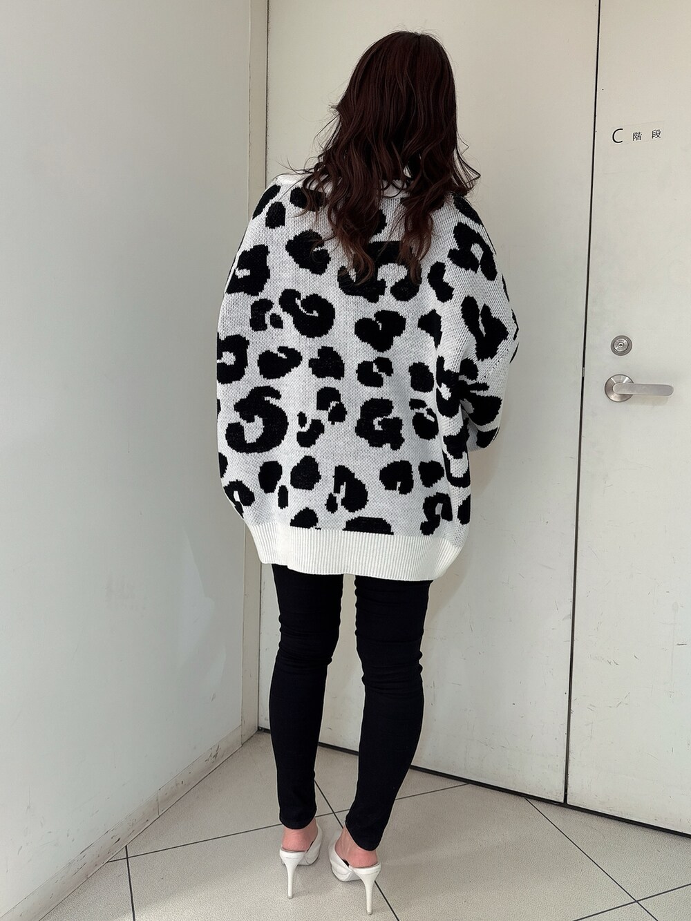 ホワイト系のカーディガン/ボレロ、ブラック系のキャミソール、ブラック系のデニムパンツを着用したレディースの春コーディネートの3枚目の写真