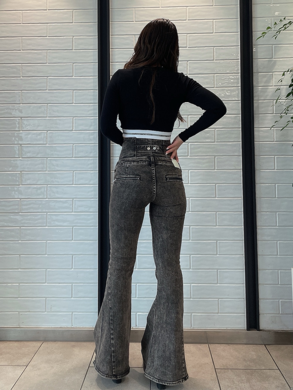 ブラック系のデニムパンツ、ブラック系のブーツ、ブラック系のTシャツ/カットソーを着用したレディースの夏コーディネートの3枚目の写真