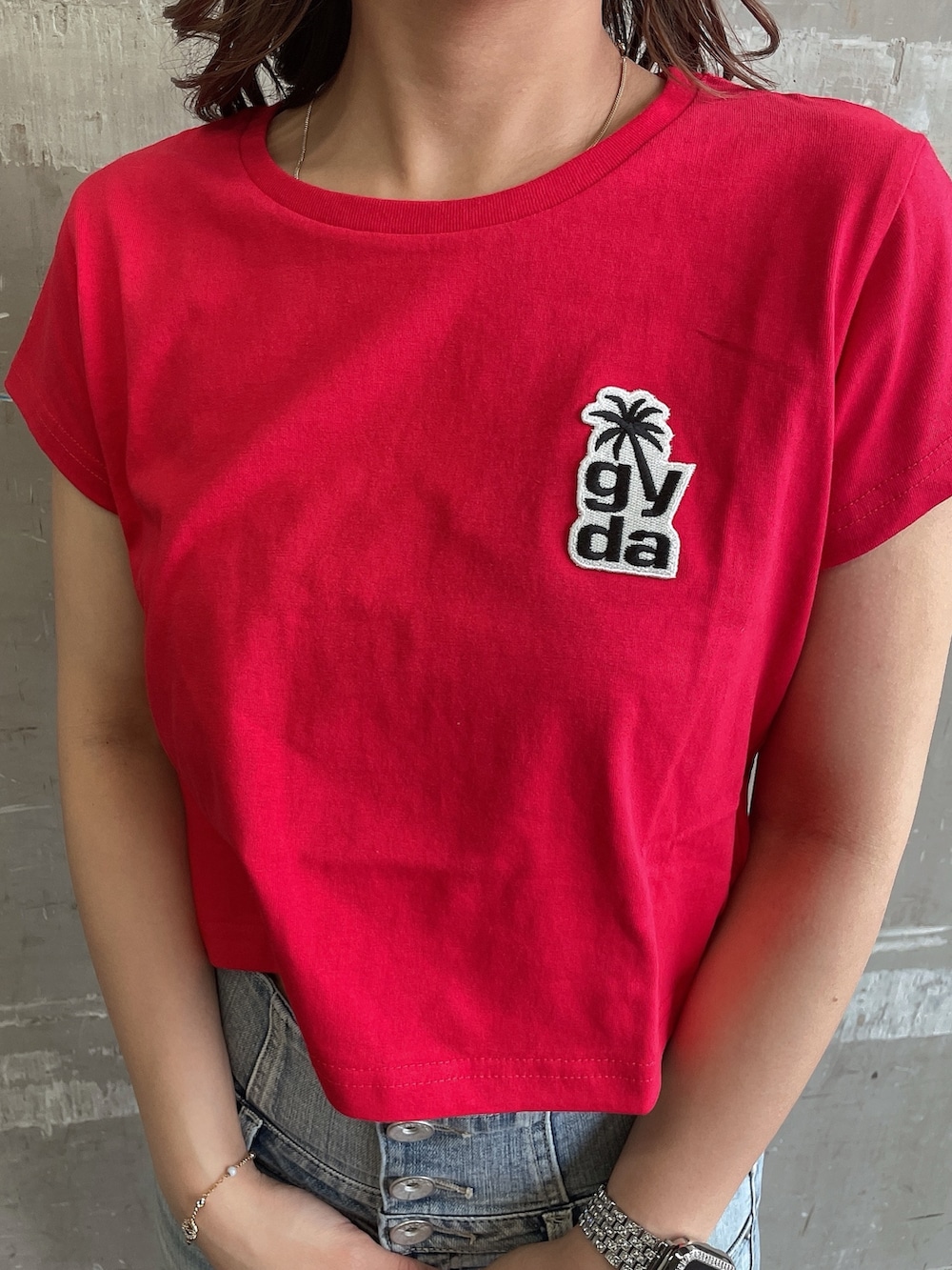 レッド系のTシャツ/カットソー、ブルー系のデニムパンツ、ホワイト系のサンダルを着用したレディースの夏コーディネートの7枚目の写真