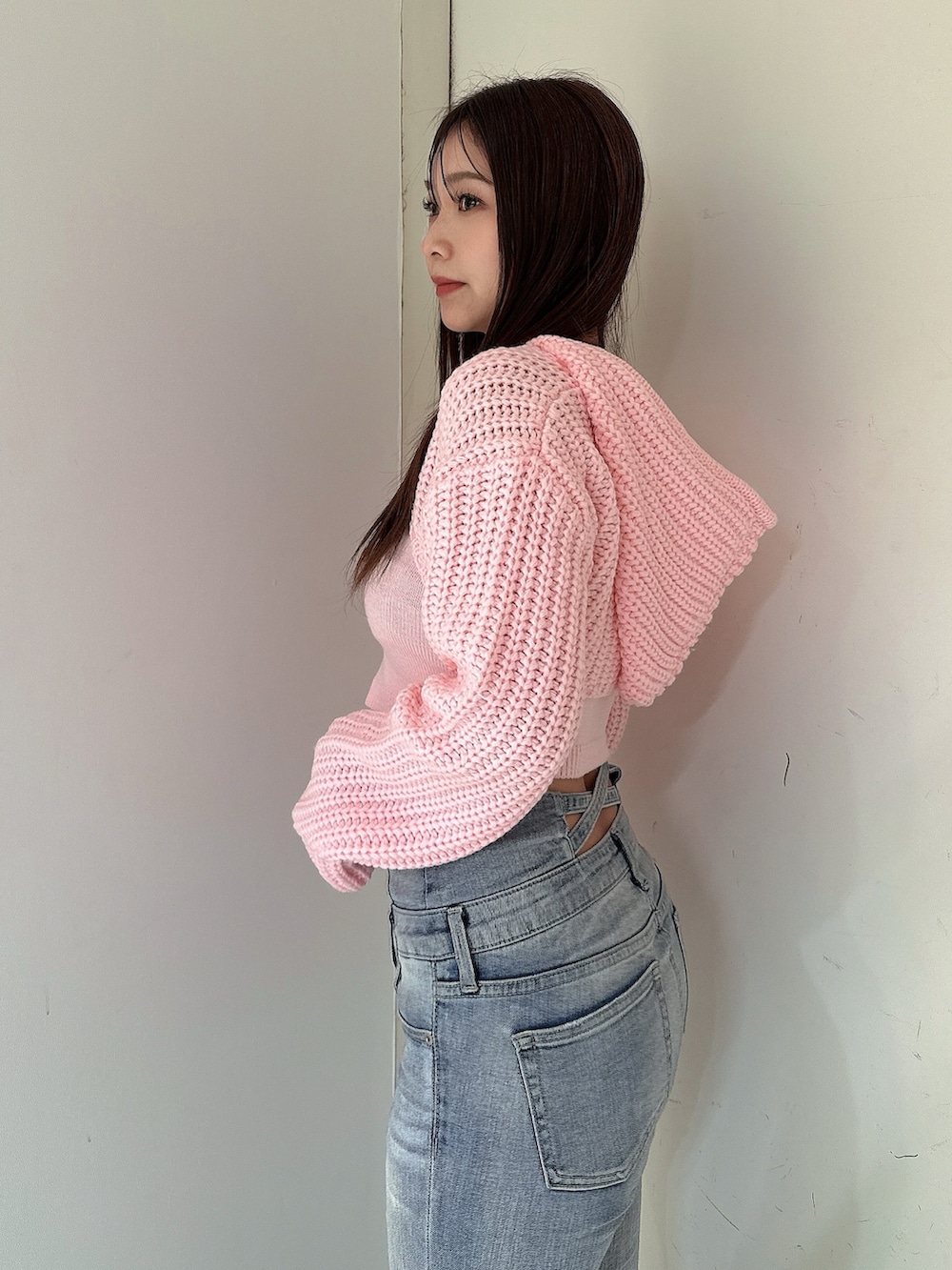 ブルー系のデニムパンツ、ピンク系のニット/セーター、ブラック系のブーツを着用したレディースの冬コーディネートの5枚目の写真