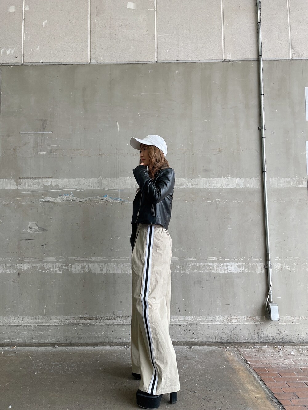 ブラック系のライダースジャケット、ベージュ系のチノパンツ、その他のニット/セーターを着用したレディースの冬コーディネートの2枚目の写真