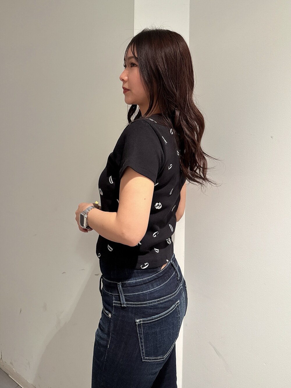 ブラック系のTシャツ/カットソー、ブルー系のデニムパンツ、ブラック系のサンダルを着用したレディースの春コーディネートの5枚目の写真