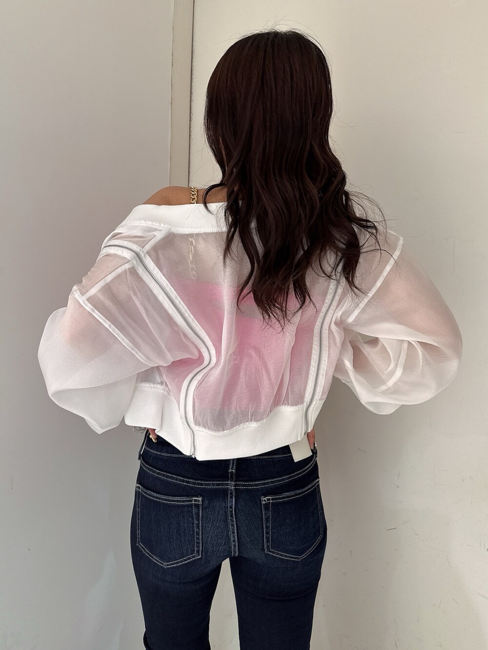 ブルー系のデニムパンツ、ホワイト系のブルゾン、ピンク系のキャミソールを着用したレディースの春コーディネートの6枚目の写真