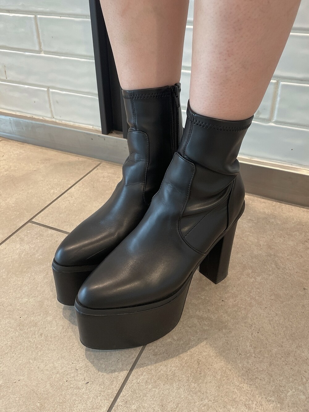 ベージュ系のニット/セーター、ブラック系のデニムパンツ、ブラック系のブーツを着用したレディースの秋コーディネートの9枚目の写真