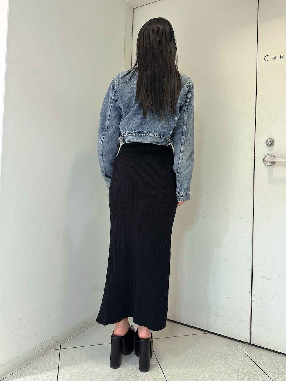 ブラック系のワンピース、ブルー系のデニムジャケット、ブラック系のサンダルを着用したレディースの春コーディネートの3枚目の写真