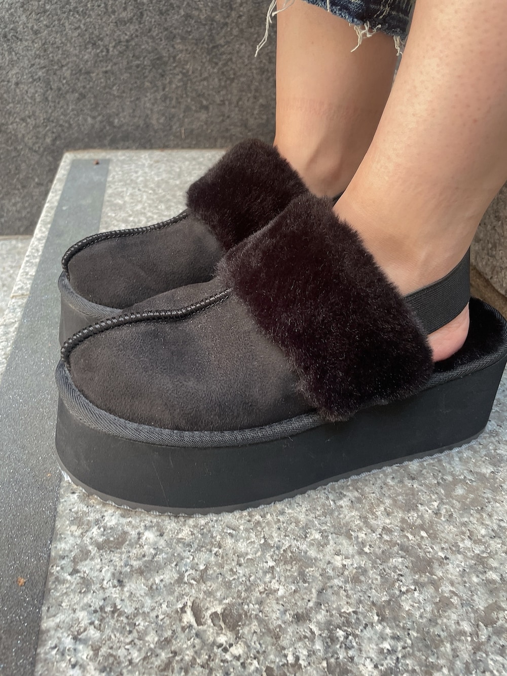 ブラック系のニット/セーター、ブルー系のデニムパンツ、ブラック系のスリッポンを着用したレディースの秋コーディネートの9枚目の写真