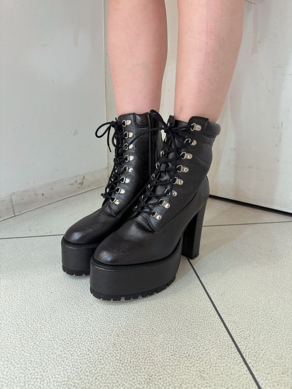 ブラック系のニット/セーター、ブラック系のスカート、ブラック系のブーツを着用したレディースの春コーディネートの9枚目の写真