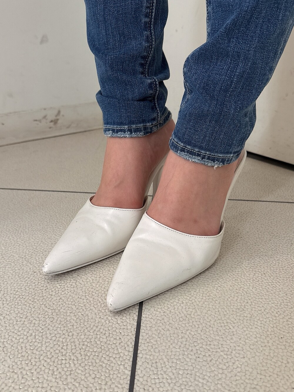 ブルー系のデニムパンツ、ホワイト系のパンプス、ホワイト系のシャツ/ブラウスを着用したレディースの冬コーディネートの9枚目の写真