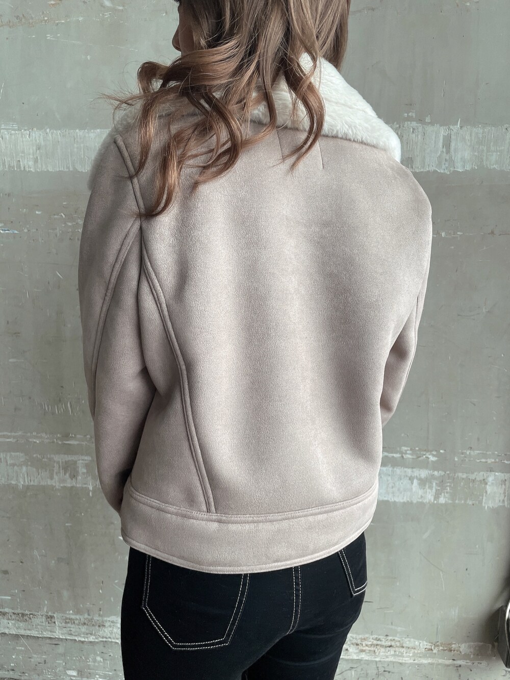 ベージュ系のムートンコート、ホワイト系のTシャツ/カットソー、ホワイト系のハンドバッグを着用したレディースの秋コーディネートの9枚目の写真