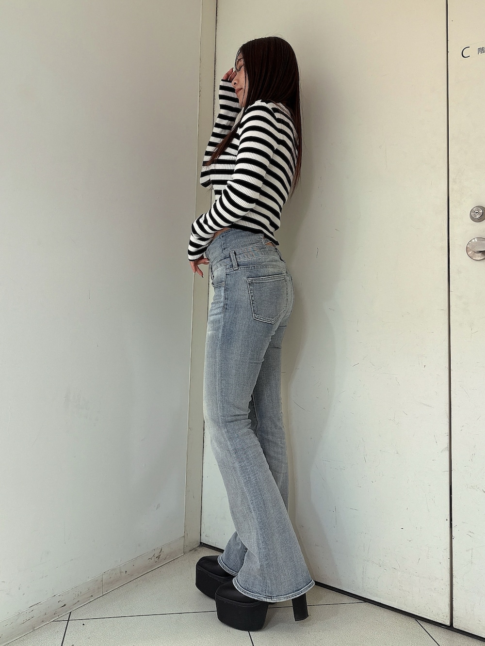 ブルー系のデニムパンツ、ブラック系のブーツ、その他のニット/セーターを着用したレディースの冬コーディネートの2枚目の写真