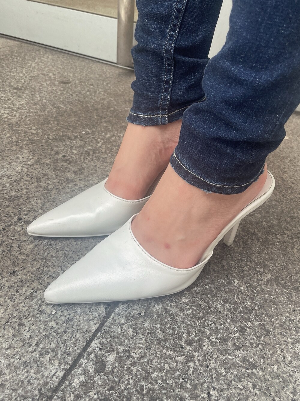 ホワイト系のスウェット、ブラック系のデニムパンツ、ホワイト系のパンプスを着用したレディースの秋コーディネートの9枚目の写真