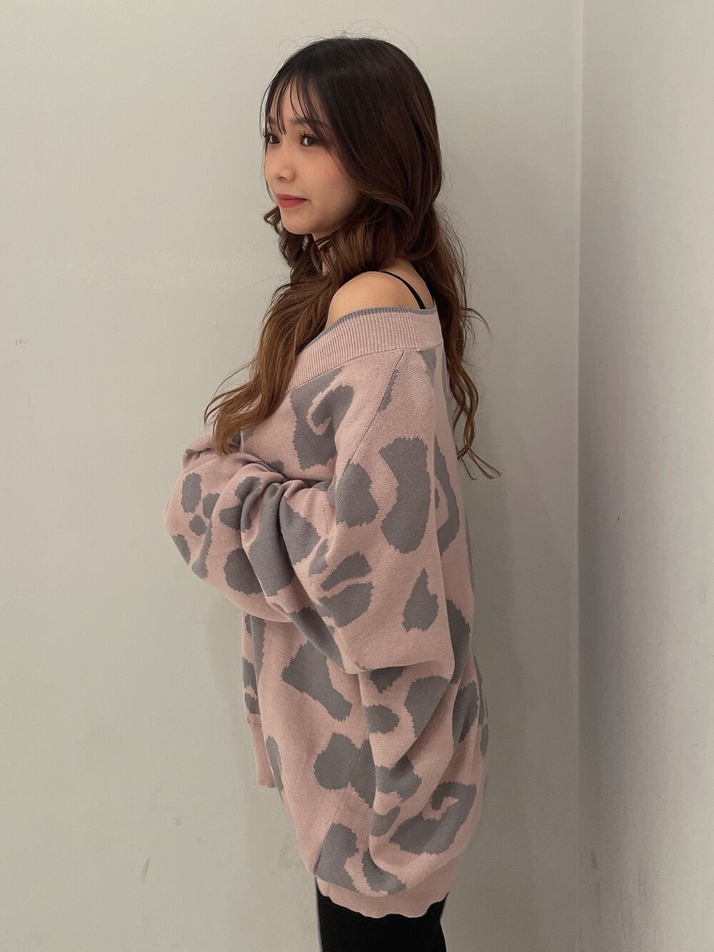 ピンク系のカーディガン/ボレロ、ブラック系のキャミソール、ブラック系のデニムパンツを着用したレディースの秋コーディネートの5枚目の写真