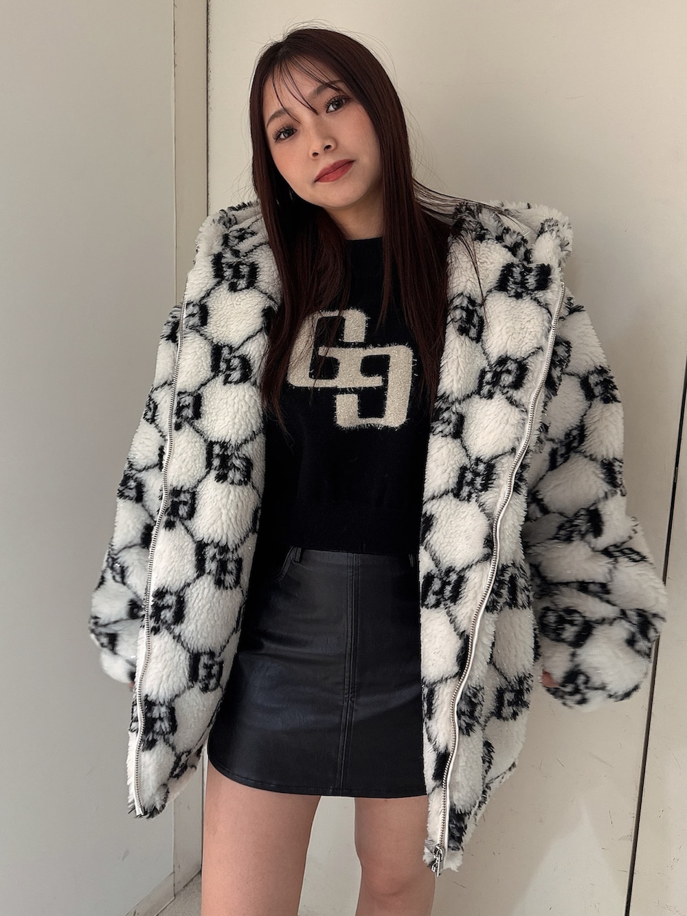 ホワイト系のブルゾン、ブラック系のスカート、ブラック系のブーツを着用したレディースの秋コーディネートの4枚目の写真