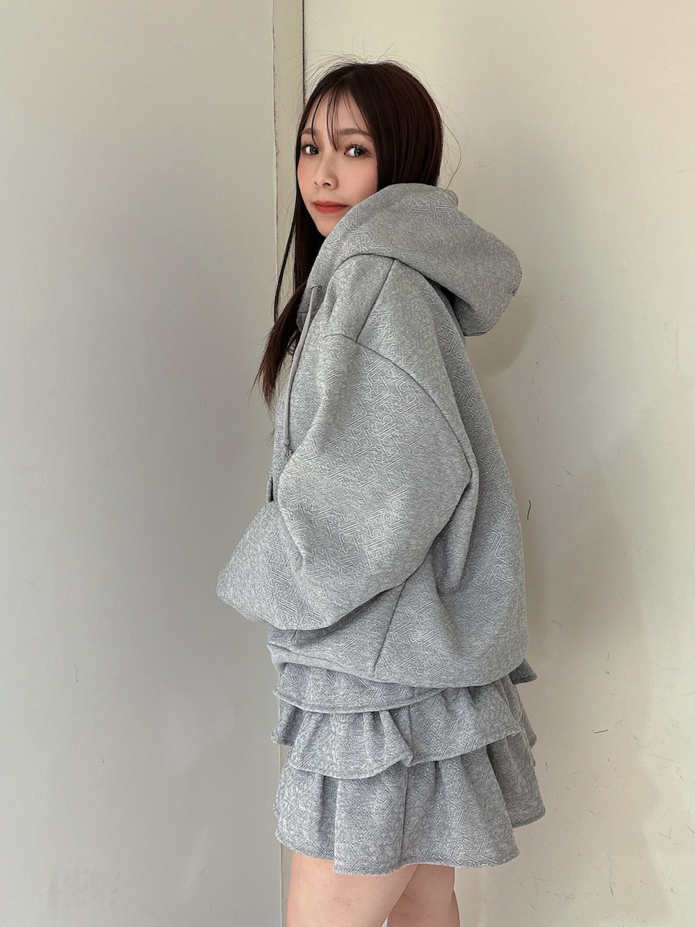 グレー系のスカート、グレー系のパーカー、ブラック系のブーツを着用したレディースの冬コーディネートの5枚目の写真